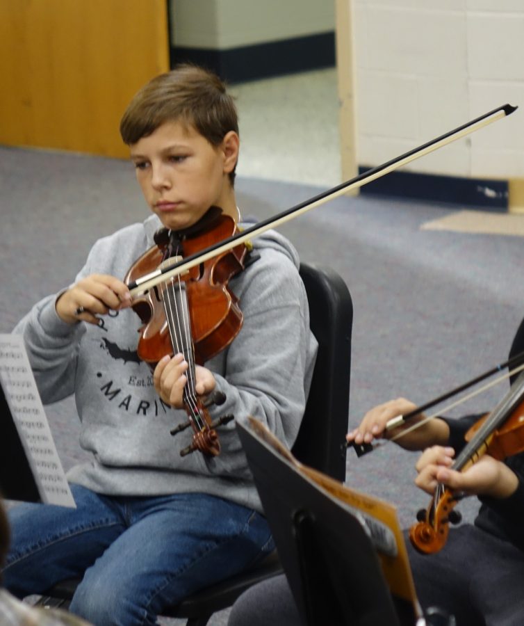 Landon Baker (8) practices his violin on October 7th in class. Baker plays the violin in 2nd Hour orchestra. Miranda Butler (8), also in 2nd hour orchestra, said she chose to play the violin “because I like to play string instruments and its the highest one so not many people like to play it.”