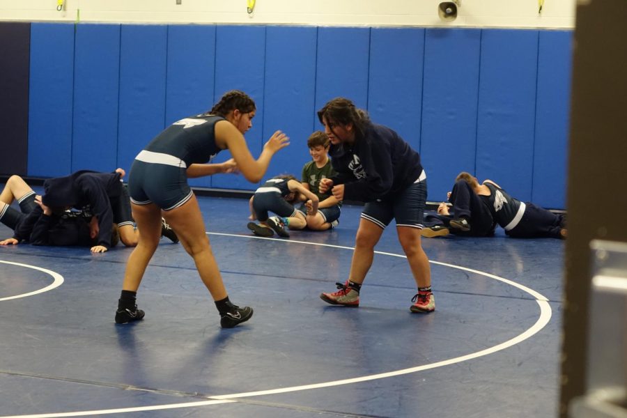 8th grader Cutzi Bedolla-Ramos and 7th grader Kyndall Keller warm up for the home wrestling meet on November 14th against Shawnee Heights and Junction City.