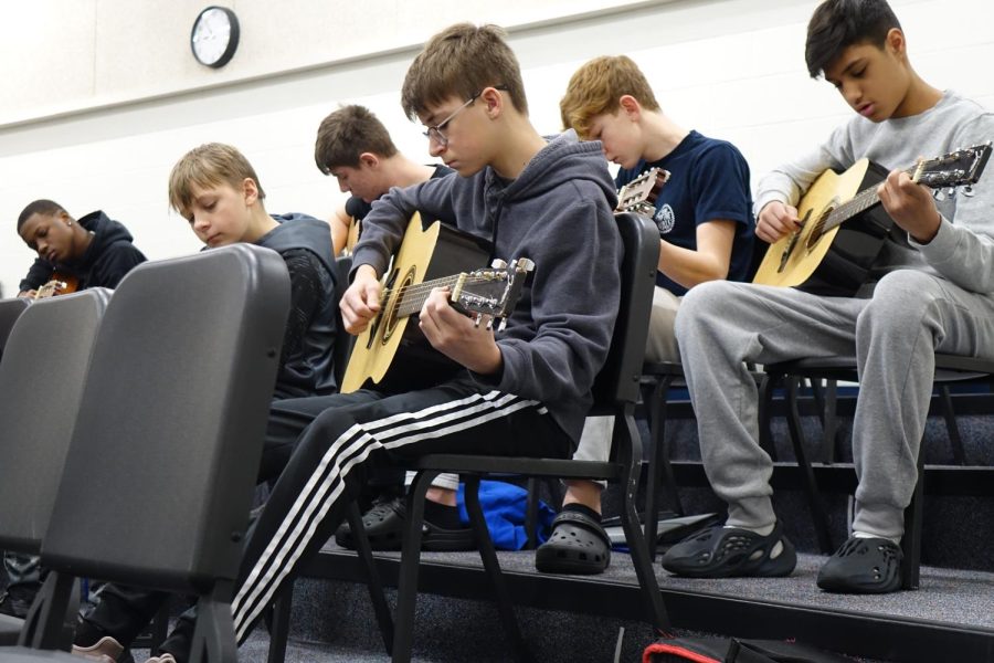 Eighth grader Conley George plays guitar in Mr. Lambottes room as part of second hour guitar class on January 25th. Story by Kaylee Fernandez.