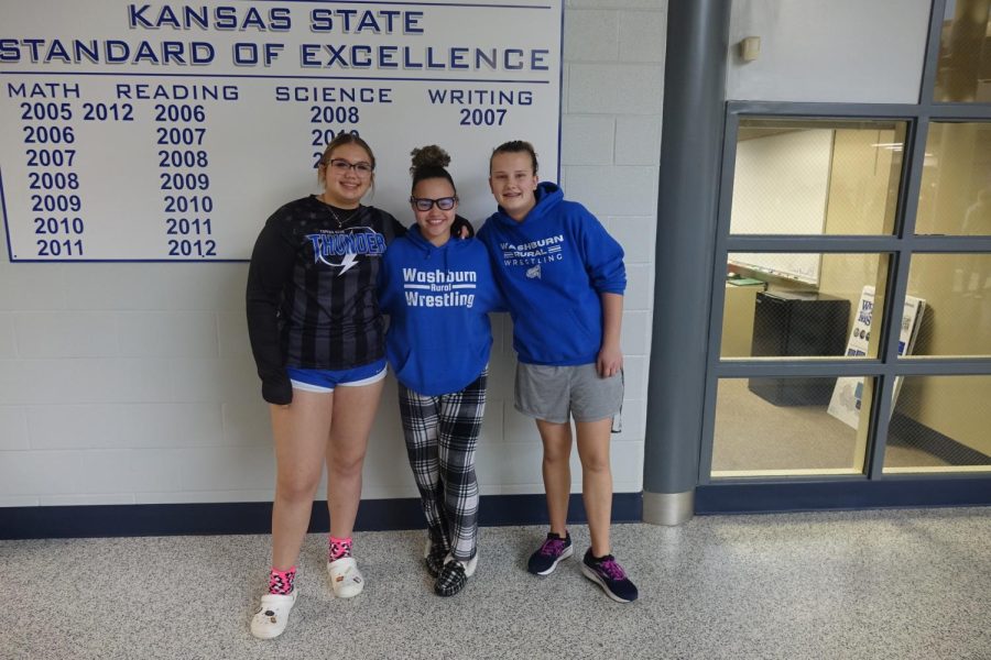  On February 23, 8th graders Justice McBurney and Quincy Summerville, and 7th grader Emma Mehl pose for a picture with their wrestling apparel.