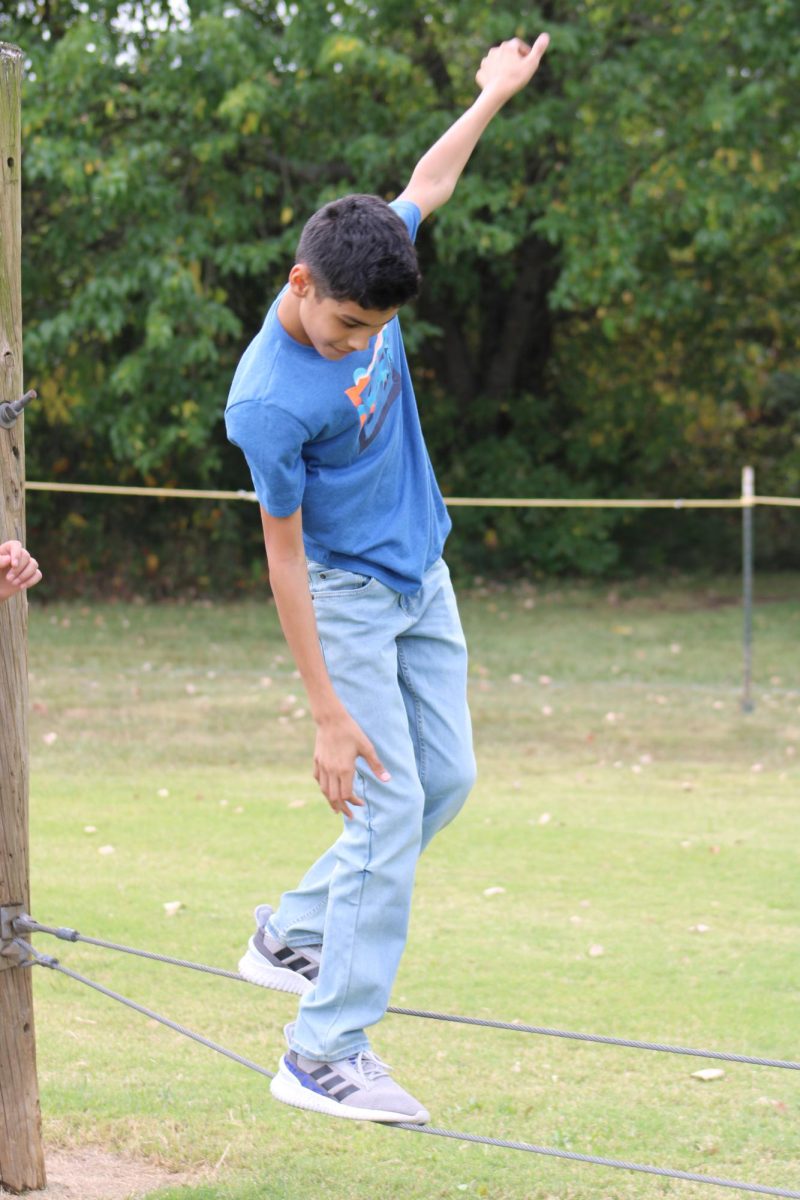 On September 21st, 8th grader, Dominic Vargas, attempts balancing on two wires to get to the next obstacle, at the WRMS challenge course. Dominic slanted his hands at an angle to get better balance, and to take his next step. 