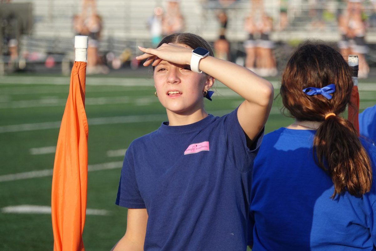 On September 8th, Payton Lister, 8th grade band student, stands and blocks the sun with her color guard flag before the pregame show at Brown-Glaze stadium starts.
