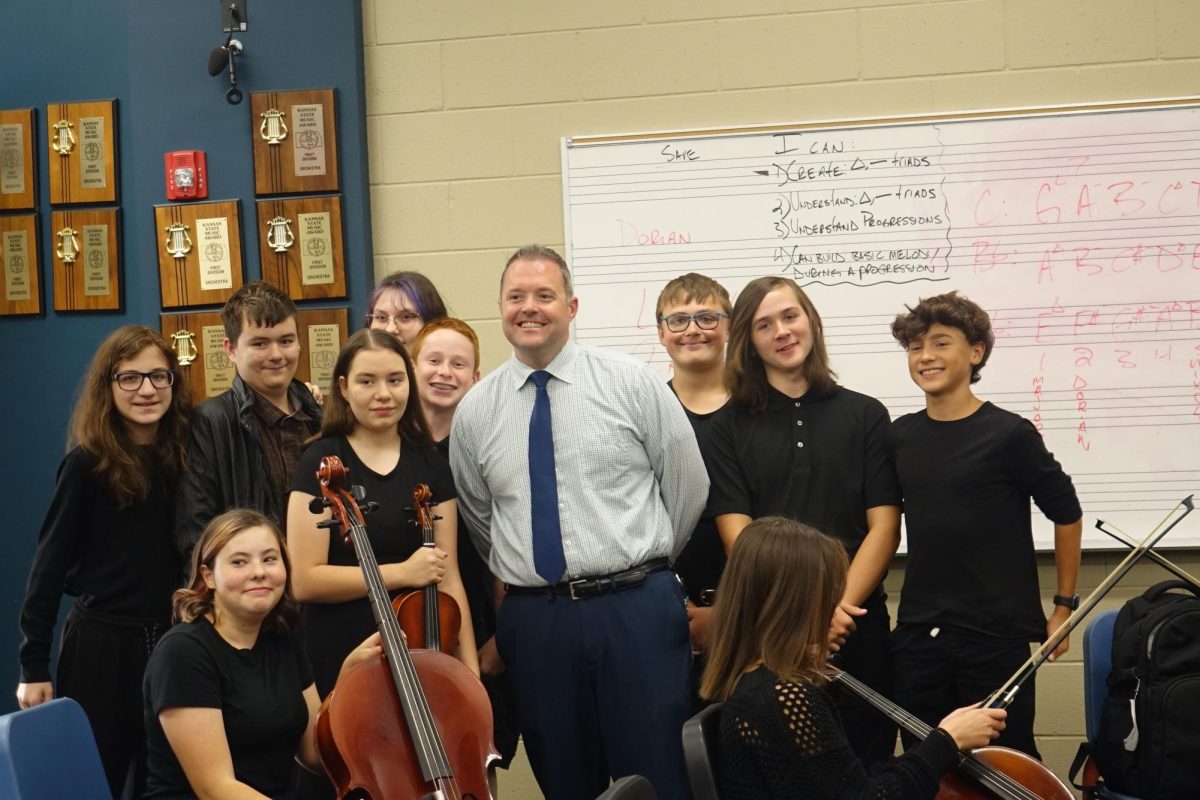 Dr. Stoltenberg smiles for the photo with the 8th Grade Orchestra students on Tuesday October 11th at Washburn Rural High School. 
