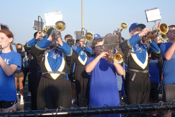 8th grade, along with high school students, stand in a formation and play their instruments for the pregame show at Bowen-Glaze stadium on September 8th.