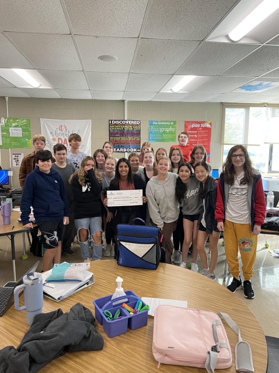 On Wednesday, October 11th, 3rd Hour Newspaper students huddle around Mrs. Grant to take a photo after she won a grant for $450 for the Falcon Feather News Website. 