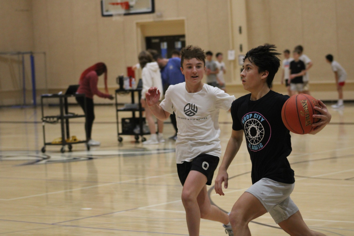 Braxton Ullery defends Everett Un in day two of basketball tryouts.
