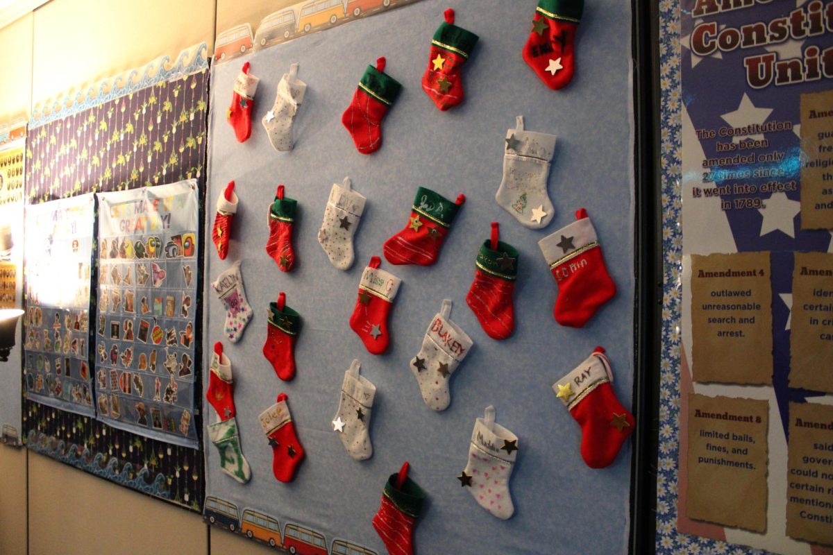 Stockings hang in Ms. Colwell’s room for her advisory students. Some of them were decorated, and she likes to put snack in them for her students. “Last week I put fruit snacks and some chocolate in each of the stockings. Today I put a candy cane and a gold coin”. 