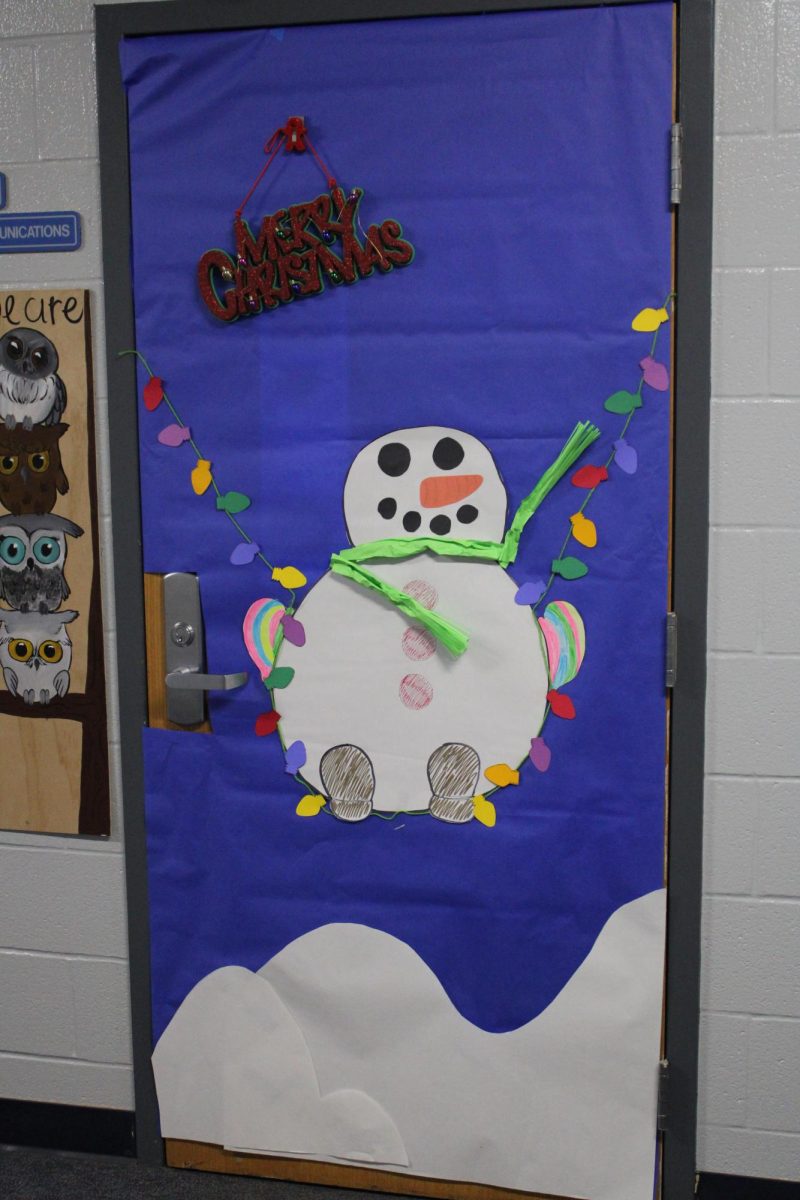 Mrs. Evans door brings holiday cheer. Decorated by a few of her students including Mary Kate Billings, Julia Mashal, Zoie Duran, and Addison Still. Mary Kate had lots of fun decorating this door “ One of my most favorite parts was just getting to be my creative self.”