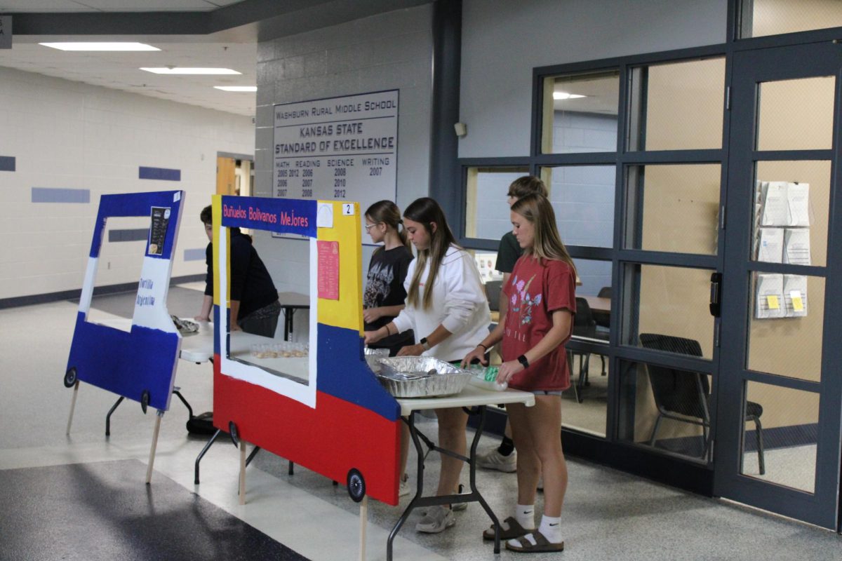 8th graders Arianna Heble, Zoie Duran, and Averi Broxterman set up their stand to get ready, and sell food at their truck Bunuelos, Bolivanos MeJores.