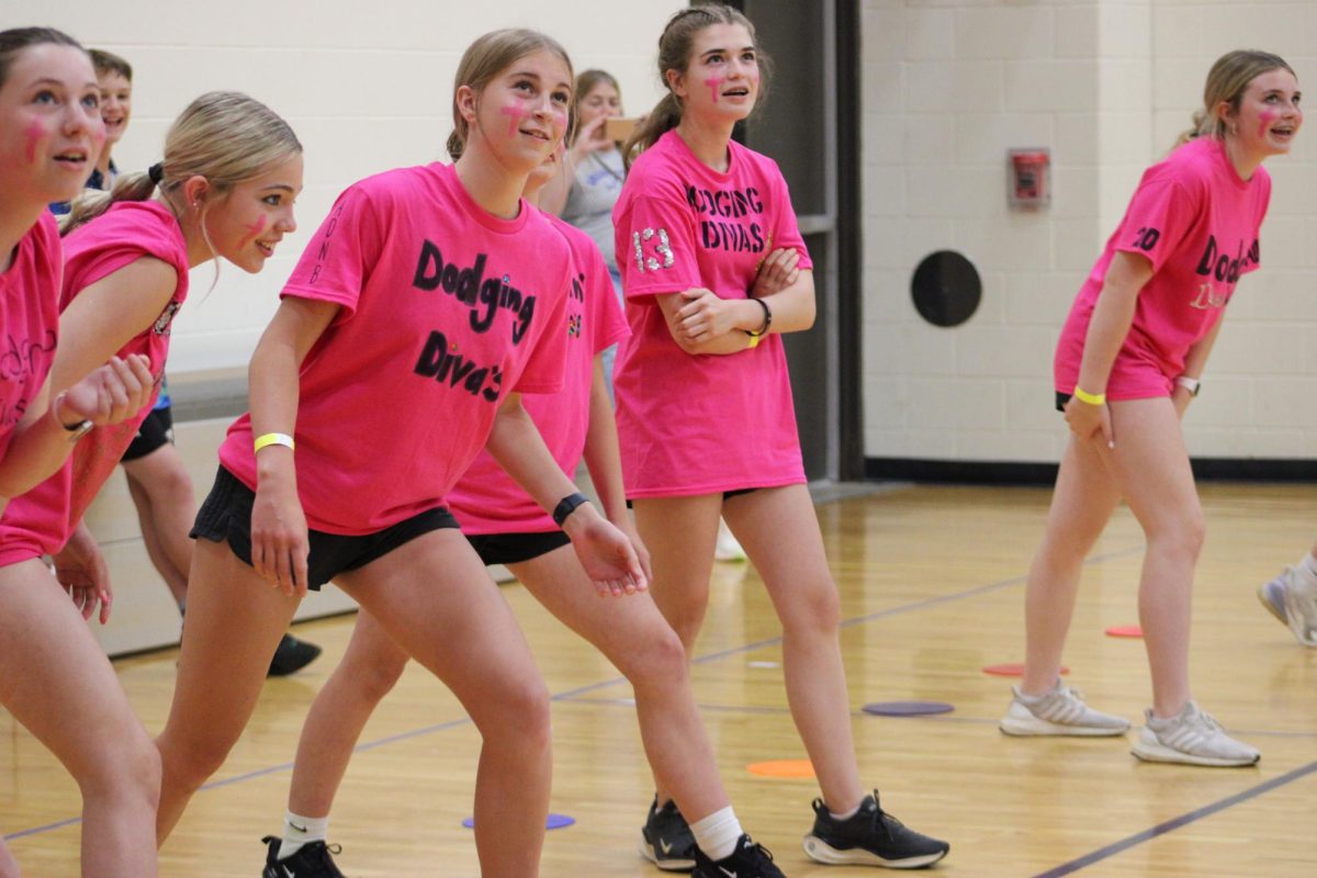 8th grader Anna Fowler and her team Dodging Divas watch the clock to know when they can start playing in Gym B. Fowler said, I think we are going to do amazing, really well.