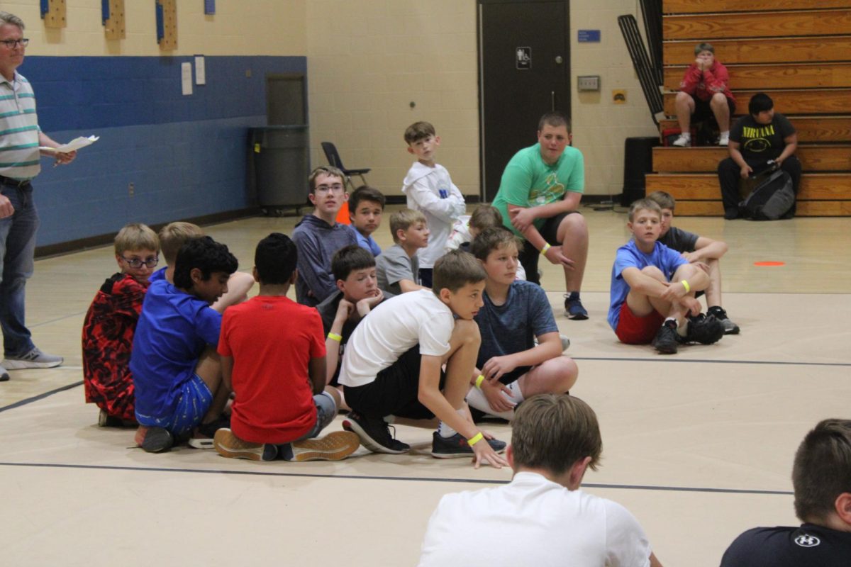 7th grader Jace Jackson sits with his team WERC Winners in Gym A as Coach C explains the rules of the dodgeball tournament. Jackson and his team created a strategy. Try our best to win and get the other teams out, Jackson said.