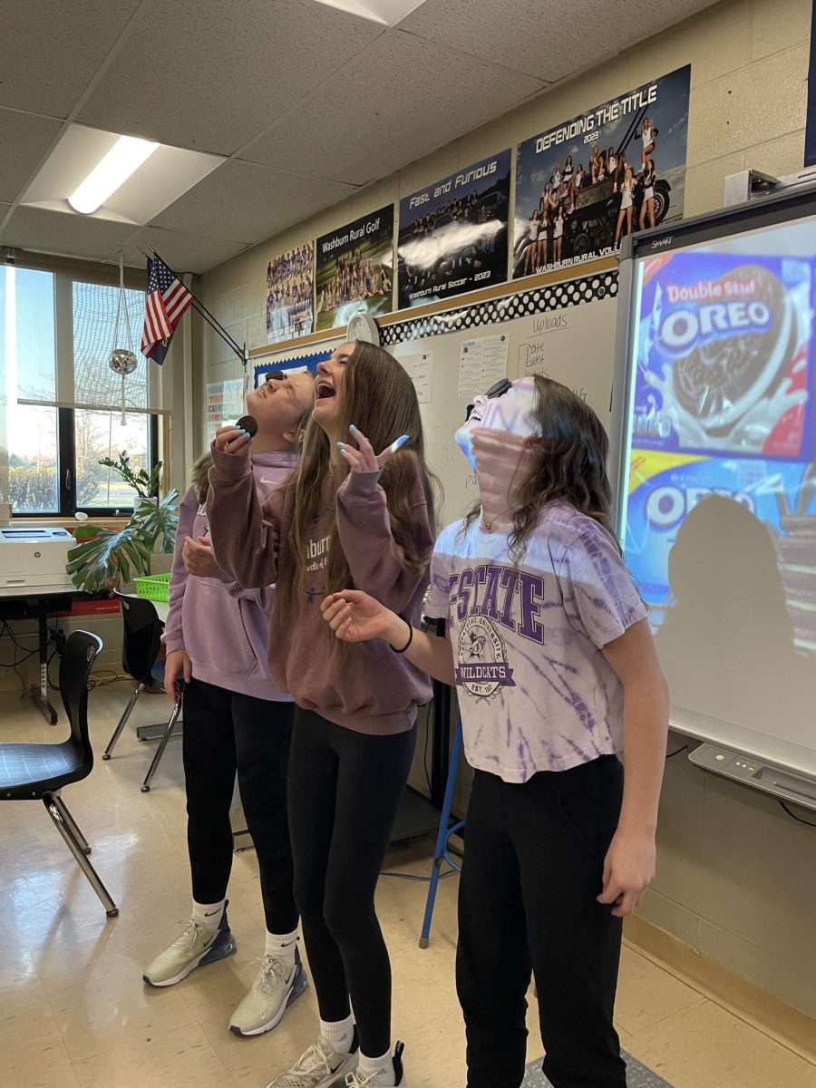 8th graders Liz Halstead, Halle Merrick, and Alayna Bivens try to get Oreos in their mouths during 1st hour on Wednesday, March 20th. The yearbook class celebrated finishing the yearbook with a "We Did It Week" where students planned fun class activities.