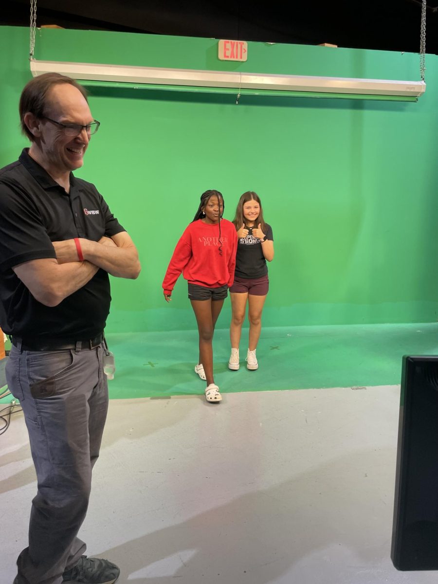 8th graders, Olivia West and Hailei Blanco walk in front of the green screen at WIBW on Tuesday, May 7th.