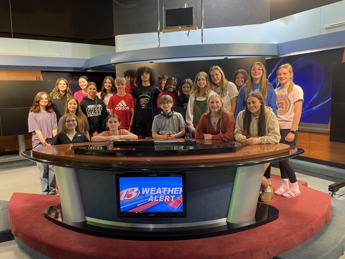 The 2nd hour newspaper class stands behind the news desk to get their picture taken at the WIBW news station on Tuesday, May 7.