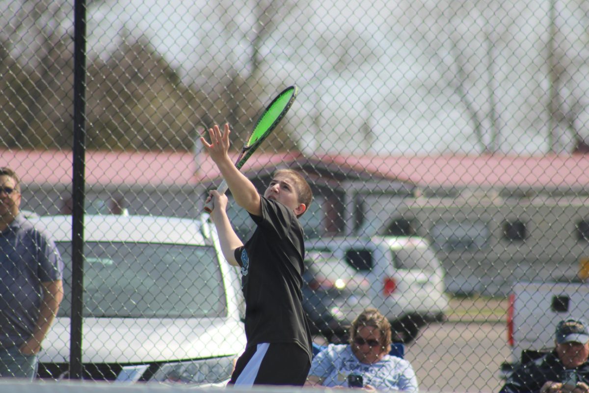 Braiden Joost, a 8th grade varsity tennis player serves in a tennis match on April 9th at the quad. Joost said, “I have been playing since 3 years old, and my dad wanted me to play.” He said his favorite memory is throwing tennis balls at people during tennis practice, and his favorite shot to do in a meet is an overhead. 
