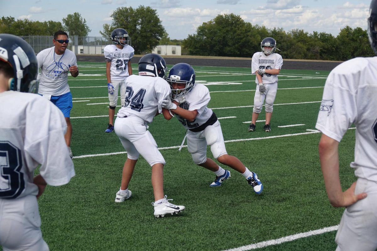 On Sept. 16, Connor Beardslee and Micah Vasquez do a hitting drill to get better and stronger, while Coach C, Kayden Simon and Logan Yocum spectate at practice on the WRMS football field.