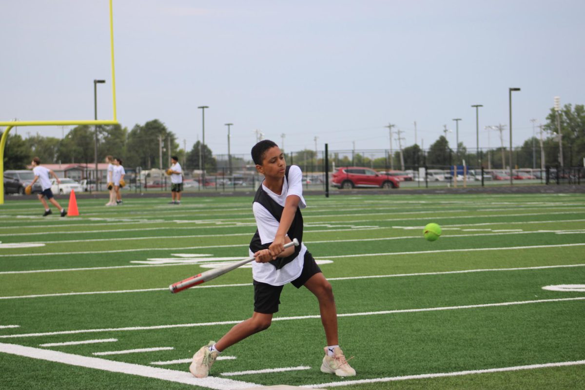 On Sept. 18, Victor Carter swings to hit the ball during his 3rd hour PE class, while playing softball on the WRMS football field.