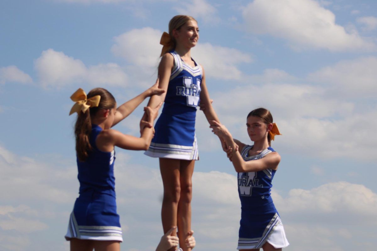        On Sept 19, Blake Classi, Ella Dittmer, and Charlotte Stryker warm up with a stunt before half time at the WRHS football field for the 7th grade football game.
