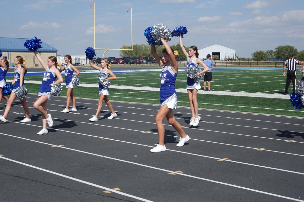 On September 18, the 7th grade WRMS cheer squad pumps up the crowd at the game against Lawrence Southwest, after a touchdown.
