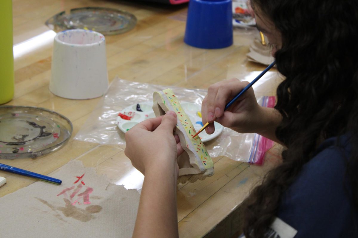 On Friday, Sept. 20, 8th grader Gabby Tinjianero paints a colorful cake in the WRMS art room for their clay cake project.