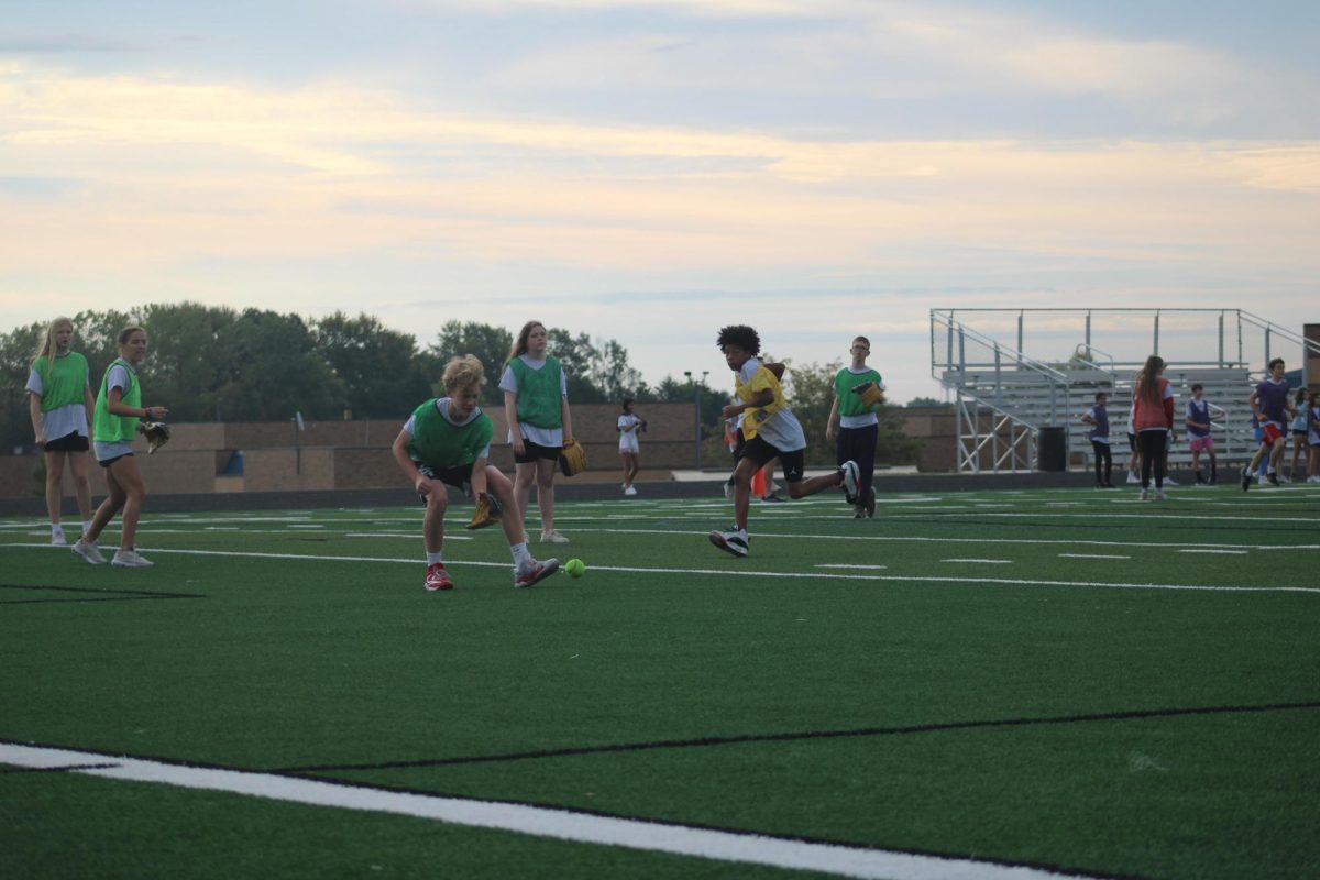 8th grader Ashton Crosswhite fields the ball to get an out at first, as Ricco Brown runs the bases, while playing softball on the WRMS football field during 2nd hour PE on Sept. 18.

