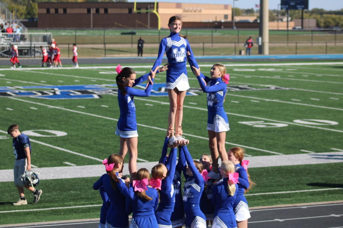 On Oct. 15, Blake Classi, Charlotte Stryker, Ella Ditmer, and the seventh grade cheer team perform a stunt for the parent/student section at the WRMS vs. Shawnee heights game. Blake (far left) said, “I like cheer because it gave me so many new friends and it's just really fun to do.” 