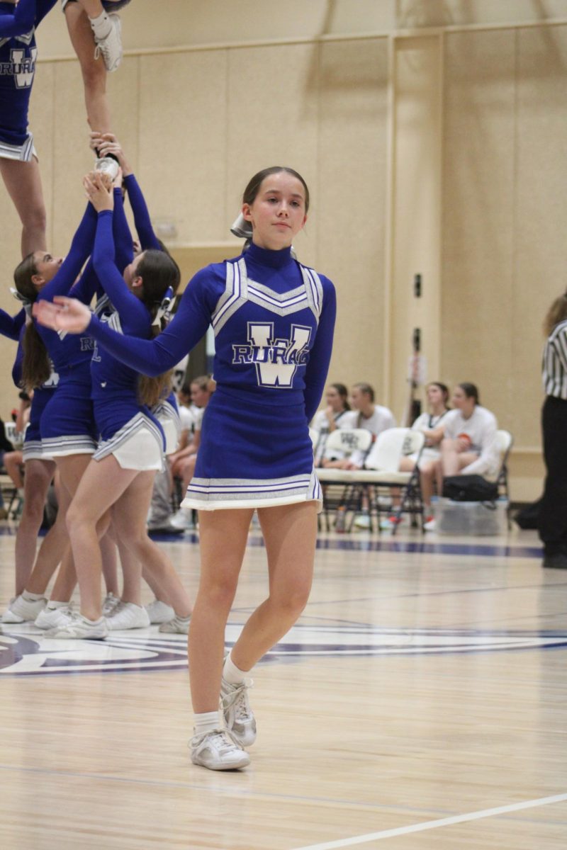 On Oct. 31 Hadley Rosenbaum waves to the crowd after she tumbles at the WRMS girls basketball game. “My favorite thing about cheer is tumbling. I love getting to do flips in front of the student and parent section at games,” Rosenbaum said. 