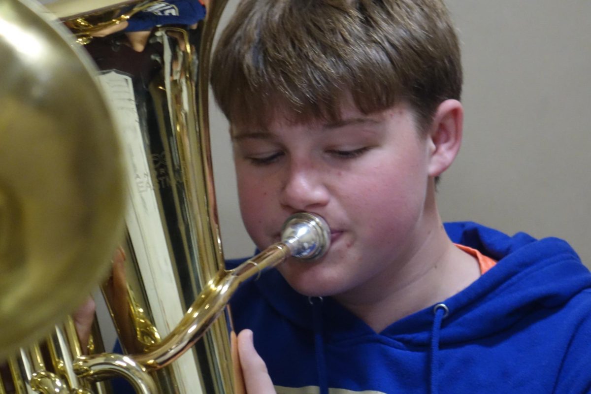 On Nov. 12 8th grader Owen Theis plays his baritone/euphonium during band class.