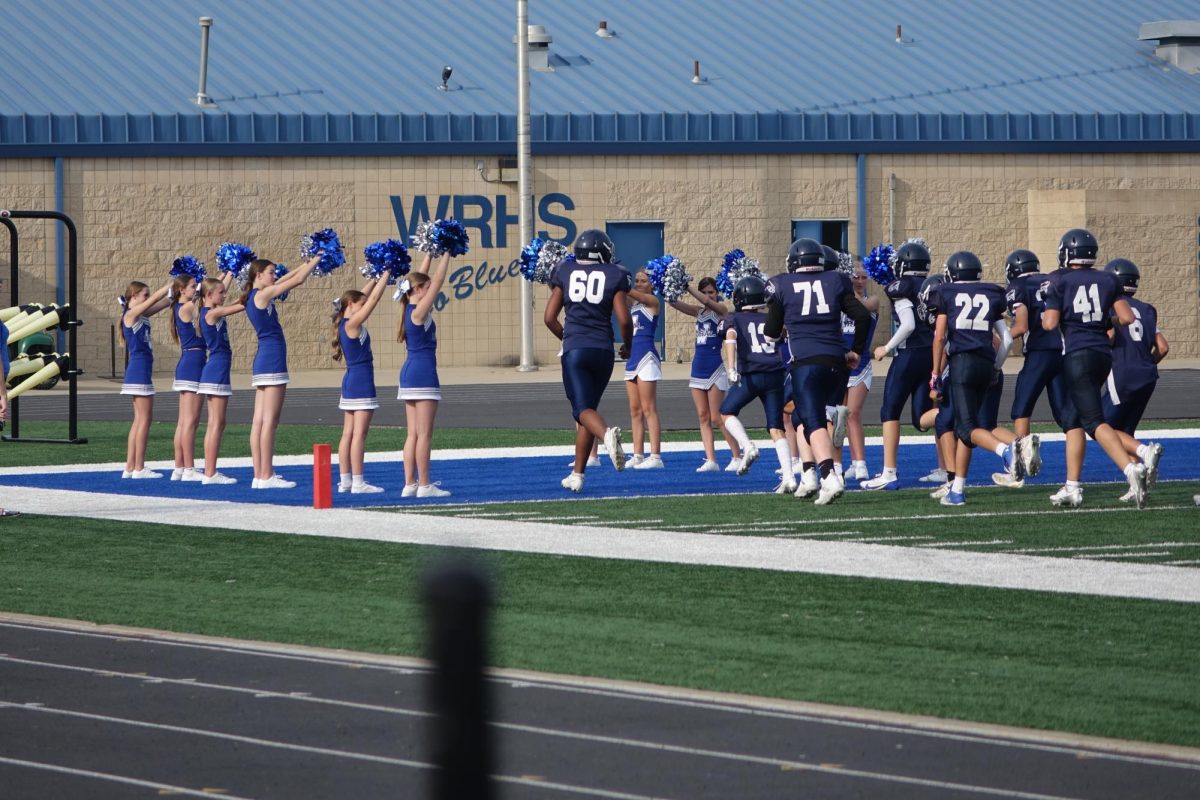 On Aug. 12, the eighth grade cheerleaders congratulate the Falcons at the WRMS football game by forming a tunnel. 