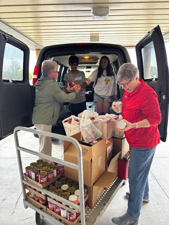 Mrs. Bertels, Mr. Moser, Arjun Mukkamala (7), and Adrianna Soto (7), load up the Harvesters van with food boxes after school on November 6th.