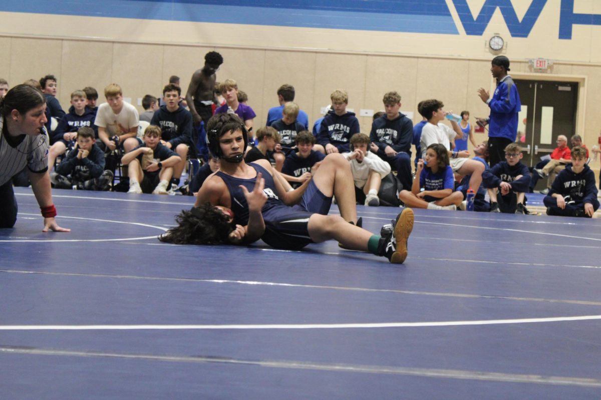 On Nov. 18, 7th grader Dominik Burns poses while pinning his opponent to celebrate the win at Washburn Rural Middle School to win the match.