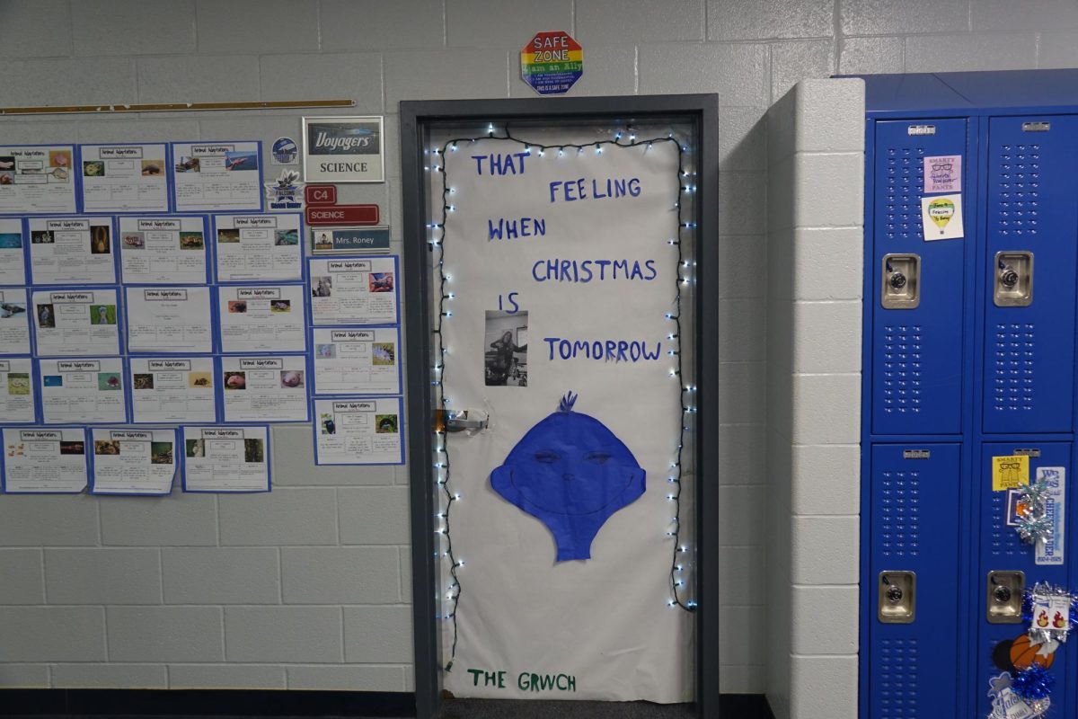 Ms. Roney’s students decorate her door as a meme during advisory in the seventh grade hallway to have a shot at winning the door decorating competition. 