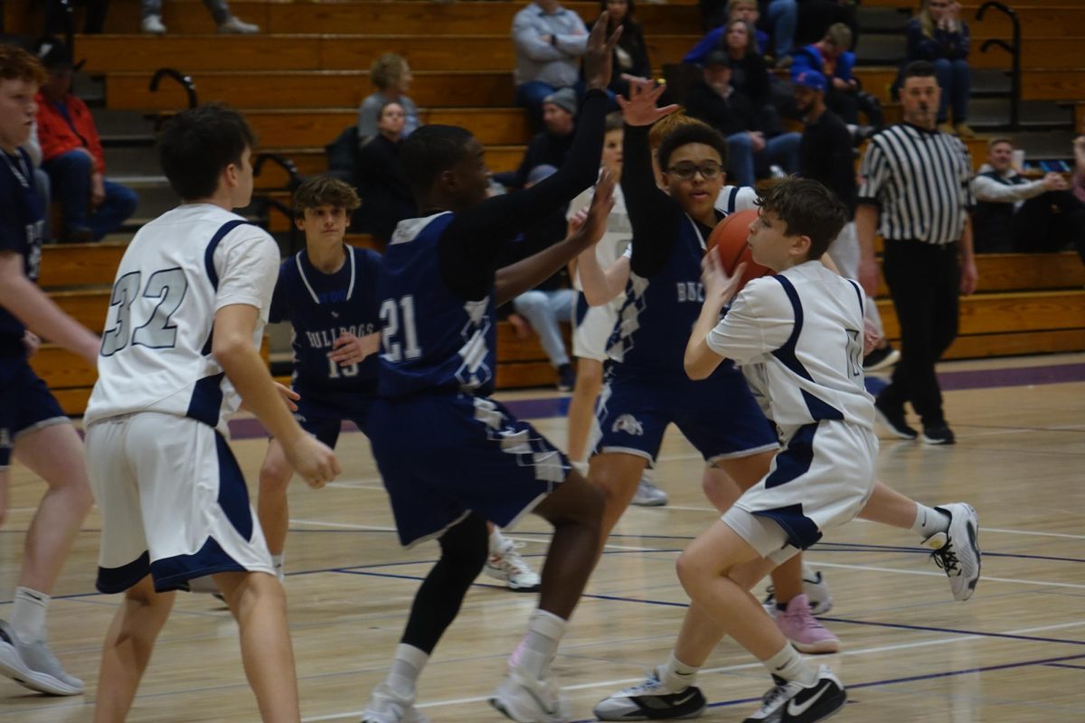 On Feb. 10, seventh grader Acyn Gilbertson tries to pass the ball to his teammate to score against Lawrence SW during the basketball game at WRMS.