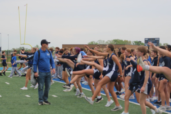 Coach McDaniel observing the track kids while they stretch at the WRMS football field before a meet.